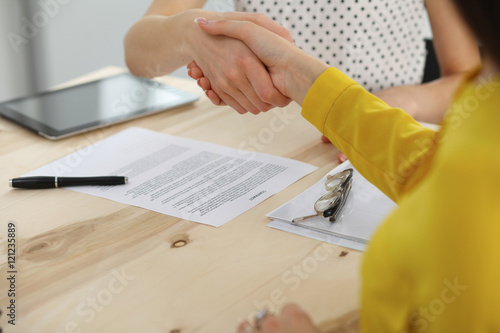 Young business woman shaking hands after signing contract