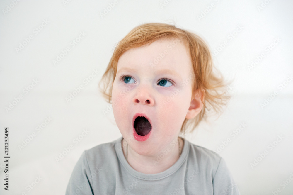 The red-haired child yawns The red-haired child yawns