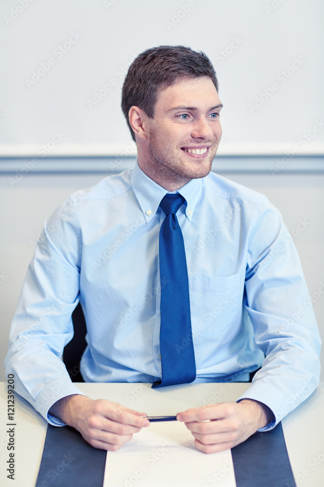 smiling businessman sitting in office smiling businessman sitting in office