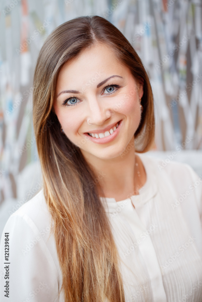 Closeup portrait of beautiful smiling nice young white Caucasian business woman with blue eyes long blond hair wearing white office blouse shirt, looking in camera, slavic Russian face