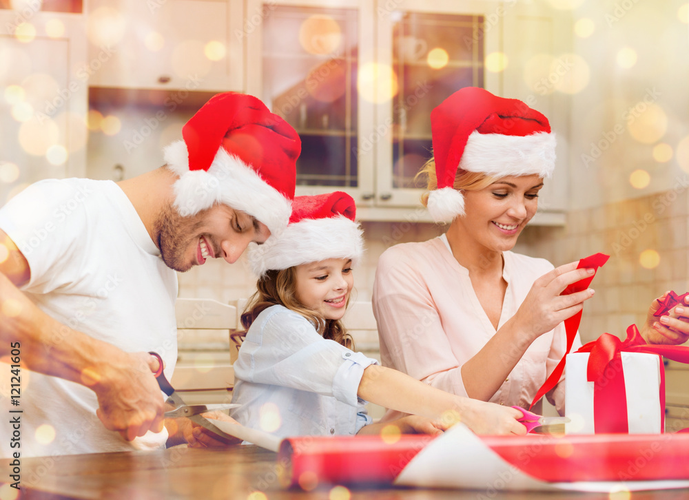 Fototapeta premium smiling family in santa helper hats with gift box