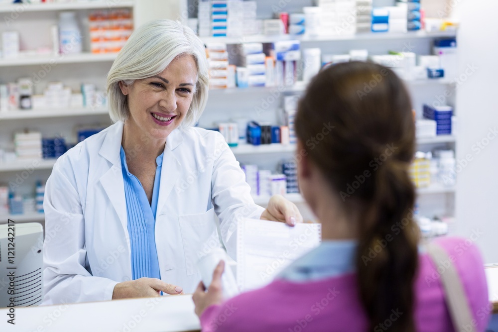 Obraz premium Farmaceuta wystawiający recepty klientowi