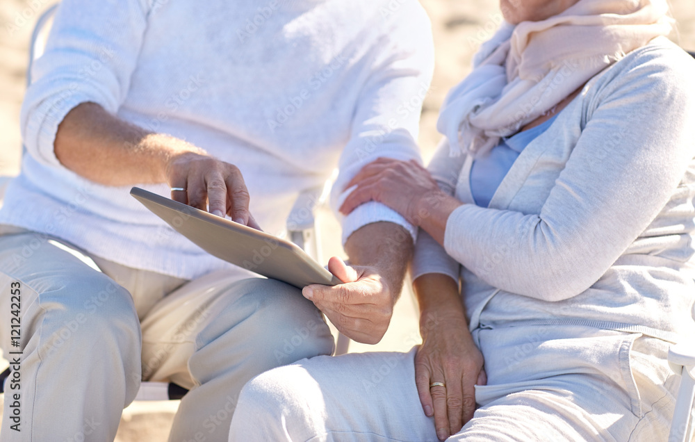 close up of senior couple with tablet pc on beach close up of senior couple with tablet pc on beach