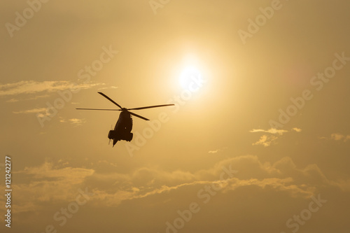 IAR Puma helicopter silhouette flying in the cloudy sky, stunt a