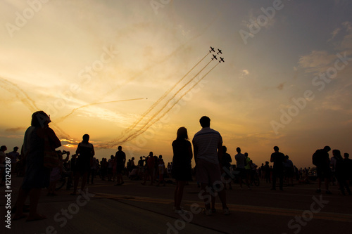 People taking pictures on a airshow at sunset photo