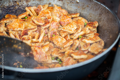 close up of meat in wok pan at street market