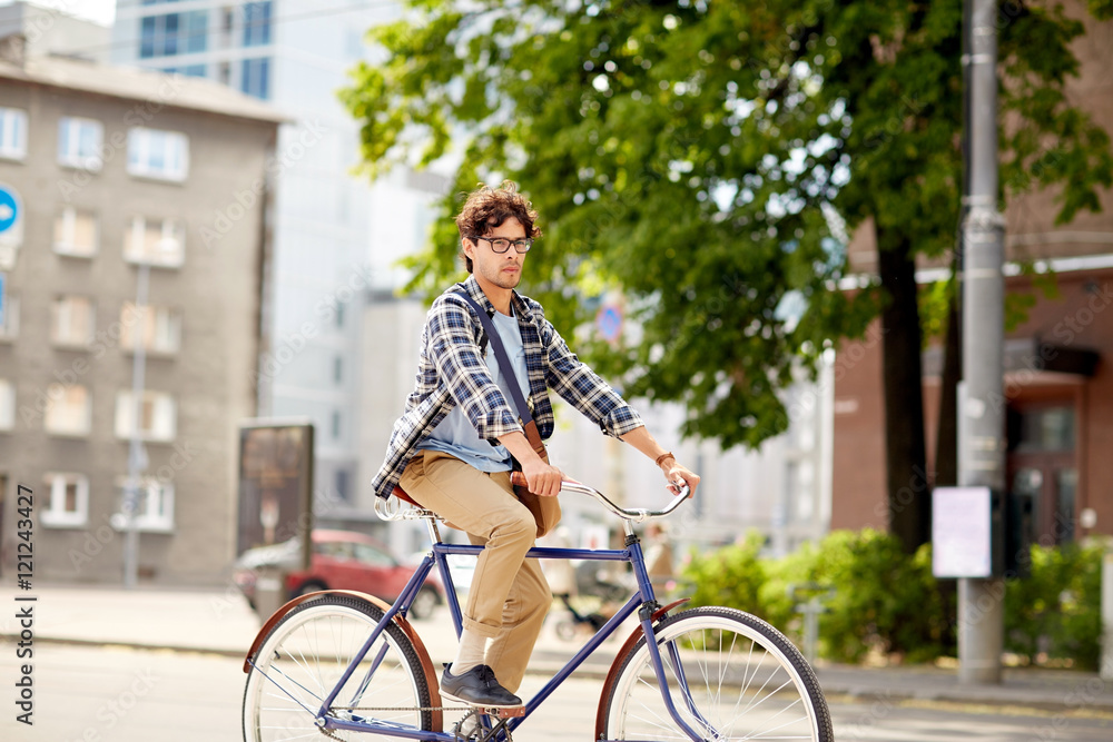 Fototapeta premium young hipster man with bag riding fixed gear bike