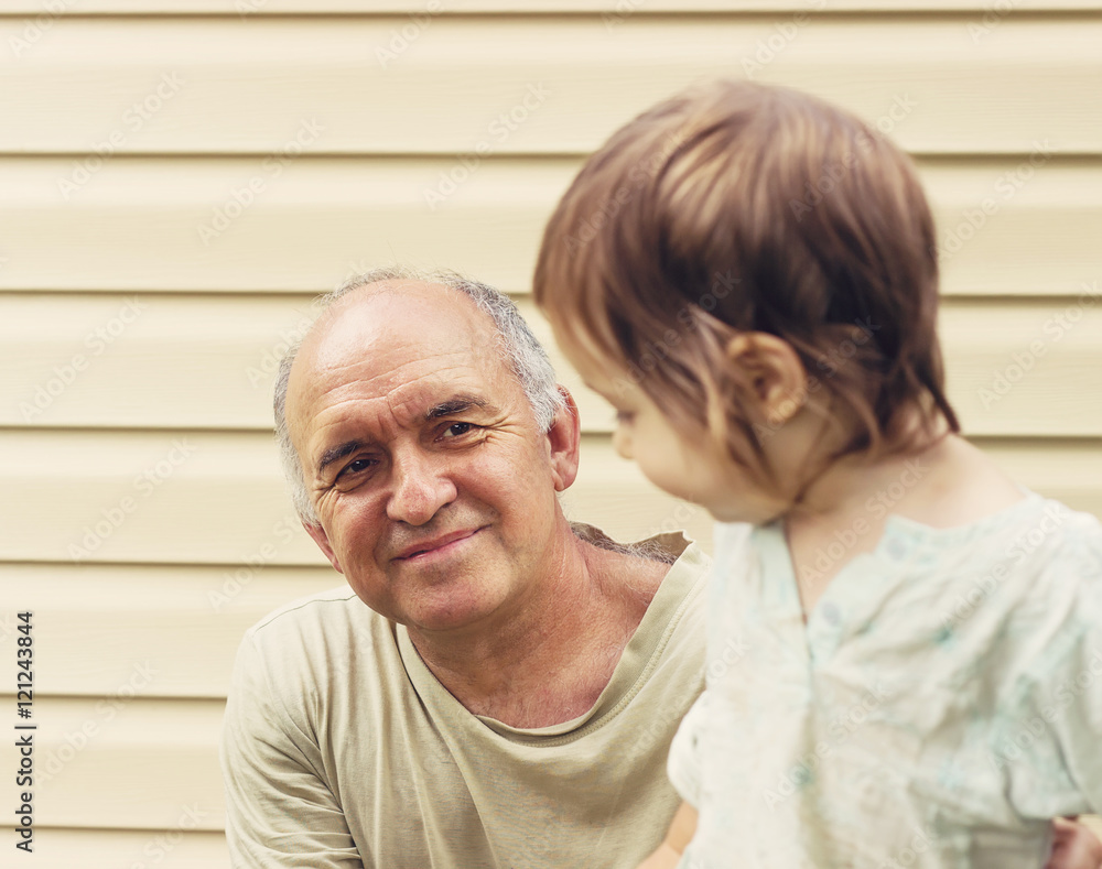 Toned portrait of Happy grandfather and granddaughter playing at Toned portrait of Happy grandfather and granddaughter playing at