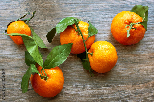 Still life of ripe tangerines with branches  on a wooden table. Top view    