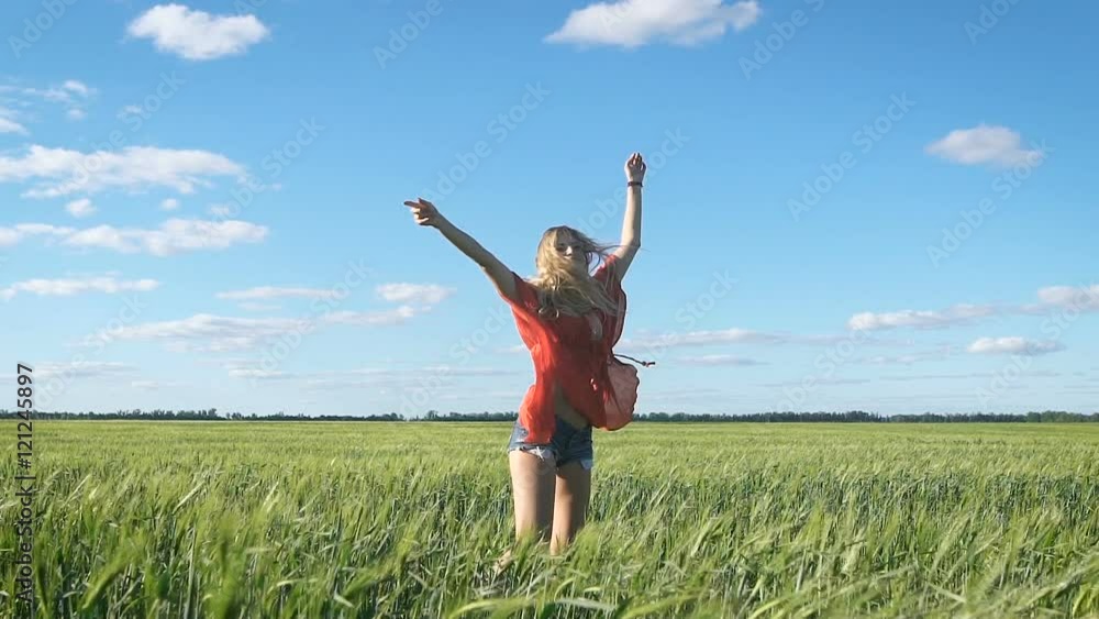 Beautiful young blond sexy woman turning around at a green field Beautiful young blond sexy woman turning around at a green field