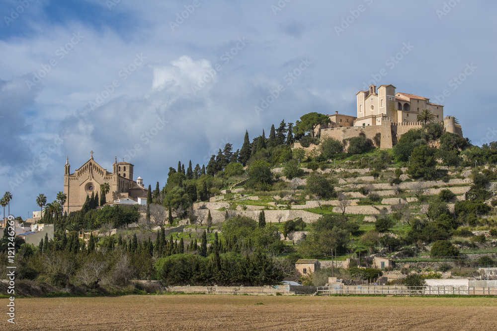 SPAIN, ,MAJORCA, ARTA, 2015-02-02: The churches Transfiguració del Senyor and San Salvador on the hilltop, surrounded by the walls of the fortress, dominate the scenery