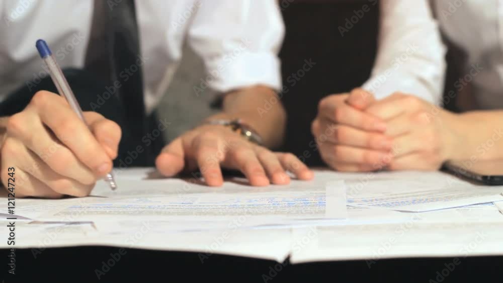 Businessman signs a document at work