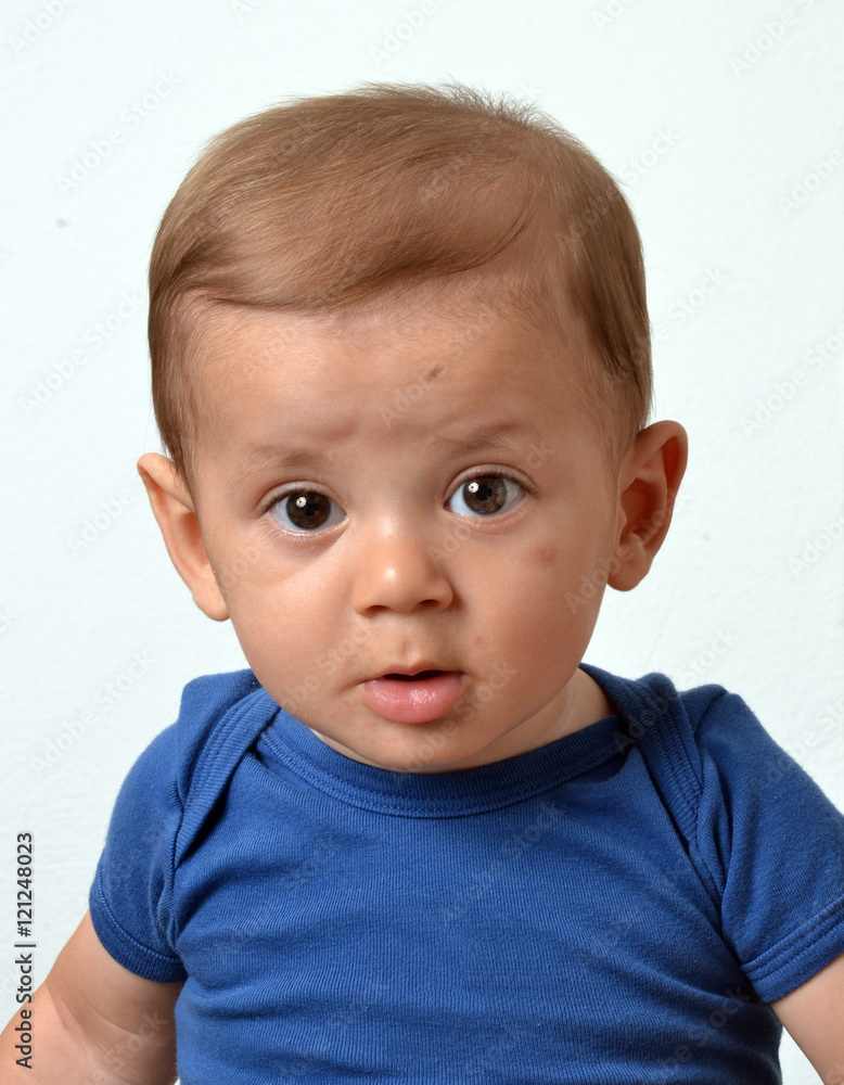 Retrato de un hermoso bebe rubio con camisa azul en fondo blanco Retrato de un hermoso bebe rubio con camisa azul en fondo blanco