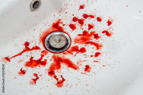 Red blood on the white sink in bathroom