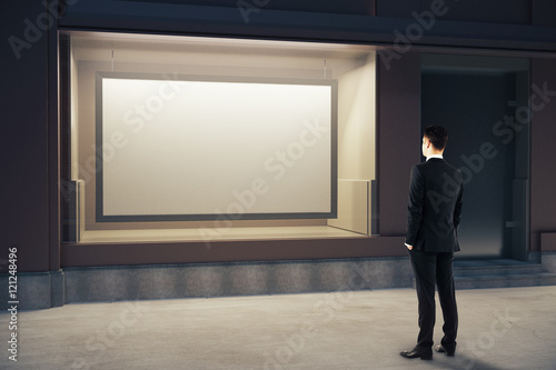 Man looking at billboard inside showcase