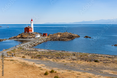 Lighthouse on Peninsula by Ocean photo