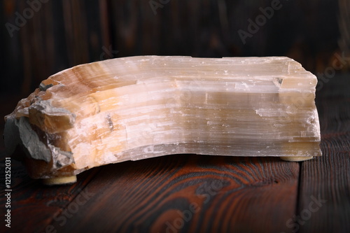 Crystal of Selenite isolated on wooden background photo