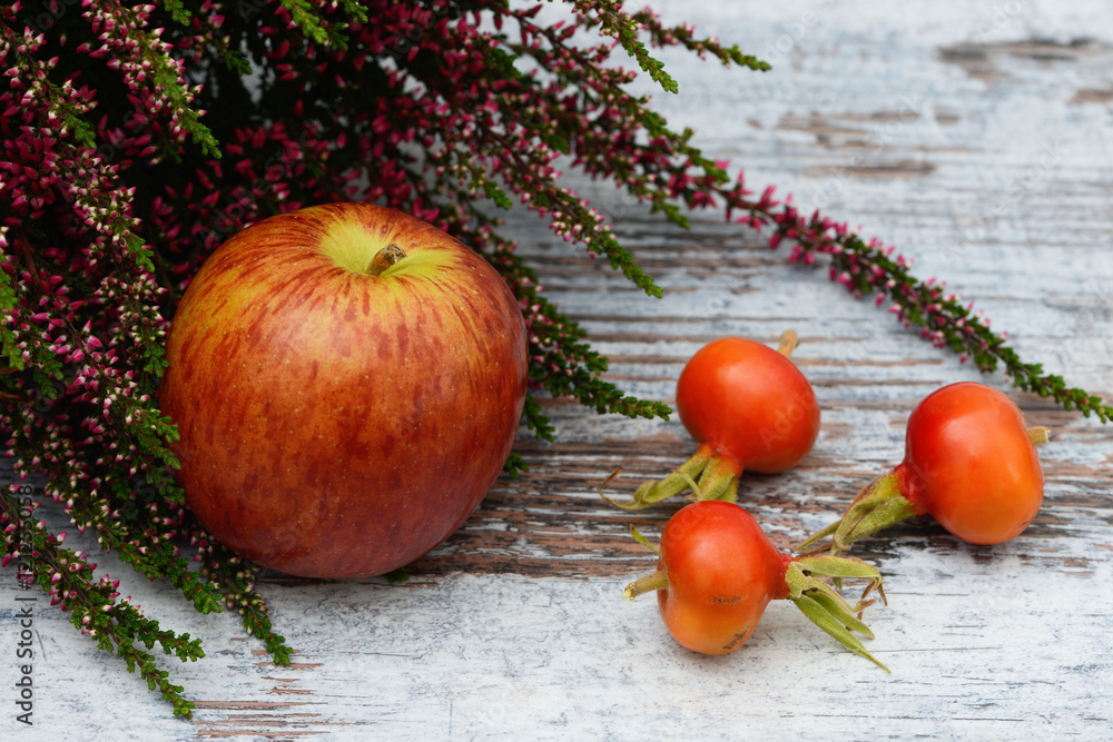 Apple, rose hip and heather lying on wood Apple, rose hip and heather lying on wood