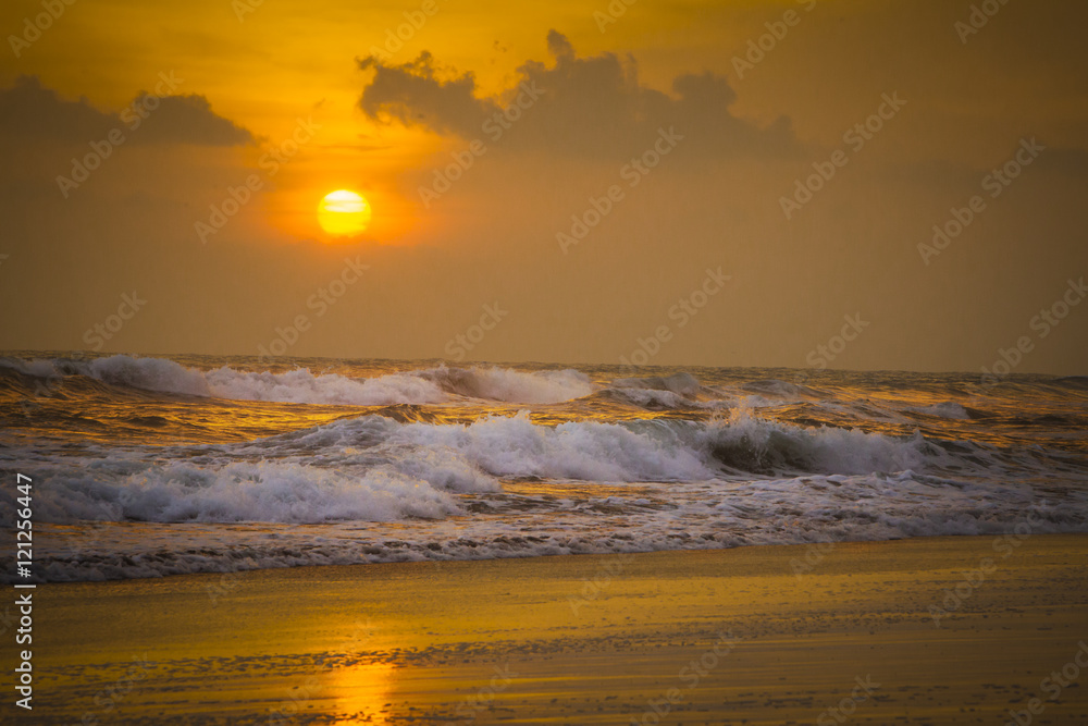 Fototapeta premium Sunset on the beach with waves crashing 2