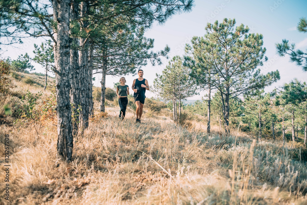 young sporty couple running in the wood young sporty couple running in the wood