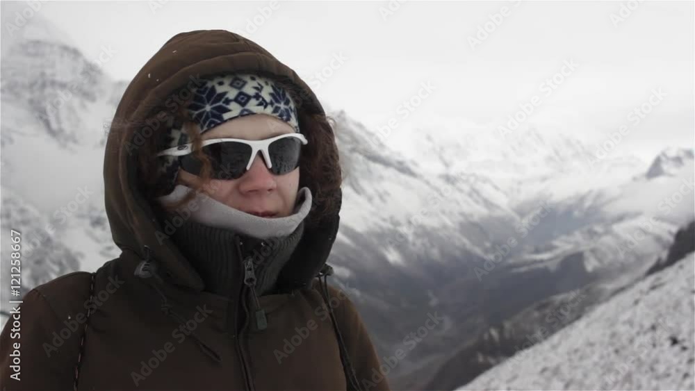 Portrait of woman standing high on the mountain covered with snow and smiling Portrait of woman standing high on the mountain covered with snow and smiling