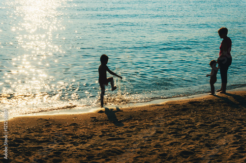 Mother and children on the beach photo