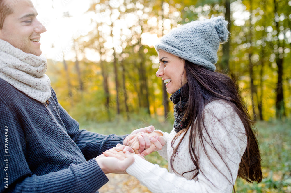 Beautiful young couple holding hands. Sunny autumn nature. Beautiful young couple holding hands. Sunny autumn nature.
