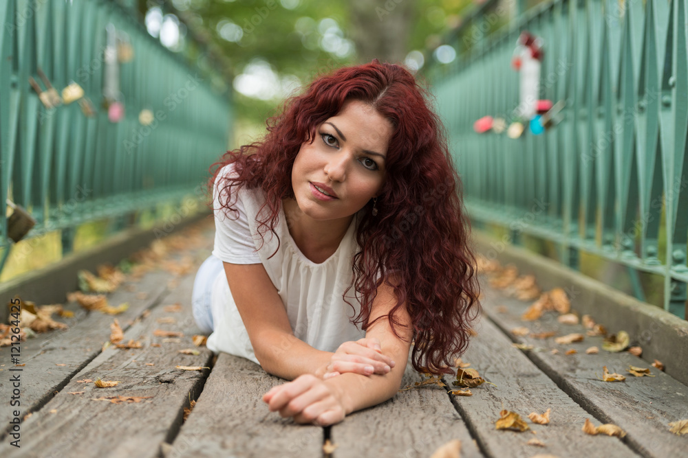 Beautiful young woman with red hair in the park Stock Photo | Adobe Stock