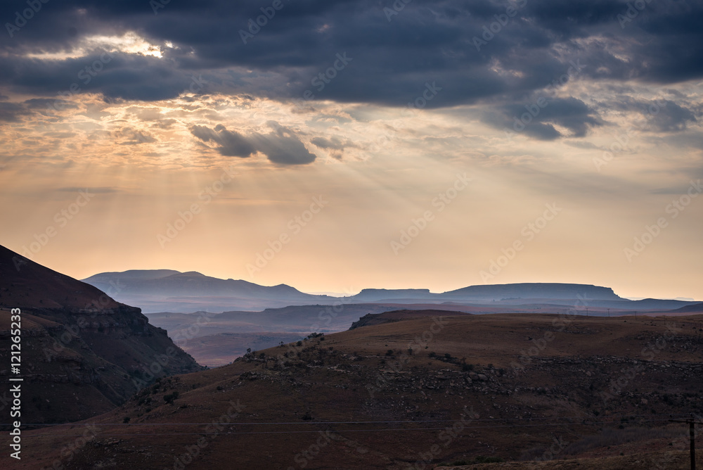 Dramatic sky, storm clouds and sun rays glowing over valleys, canyons and table mountains of the majestic Golden Gate Highlands National Park, South Africa. Dramatic sky, storm clouds and sun rays glowing over valleys, canyons and table mountains of the majestic Golden Gate Highlands National Park, South Africa.