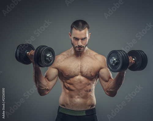Male doing biceps workouts with dumbbells.
