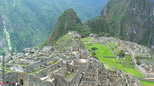 Fast zoom out from tourists walking at the Machu Picchu in Peru photo