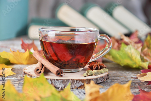 cup of tea, books on the wooden background with autumn leaves