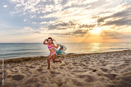 Cute Running Little Girl on Sunset Beach