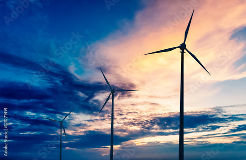 Wind generator turbines sihouettes on sunset