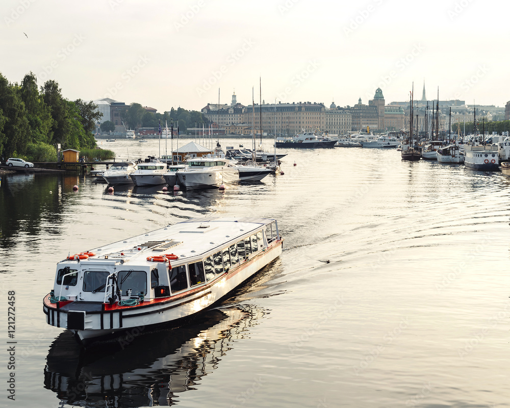 Fototapeta premium White civil passenger boat at the channel in summer