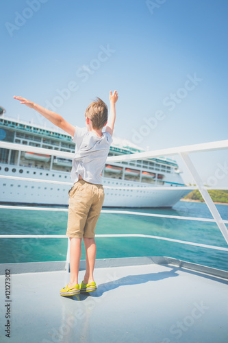 Boy waving at luxury ocean liner