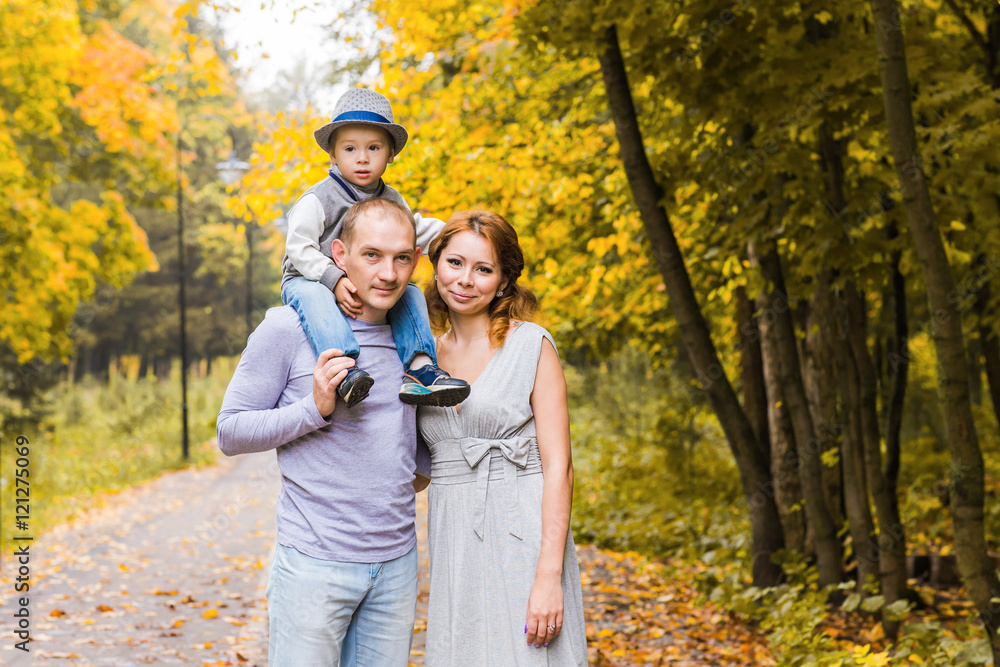 friendly family walking in the park in autumn together friendly family walking in the park in autumn together