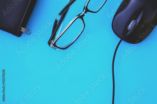 computer mouse glasses and wallet in the wooden background