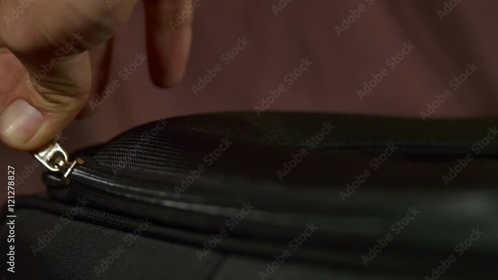 Woman's Hand Zipping The Lid Of A Suitcase Woman's Hand Zipping The Lid Of A Suitcase