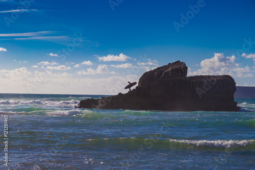 Unidentified man with surfboard on large mountain rock at Tonel © beketoff