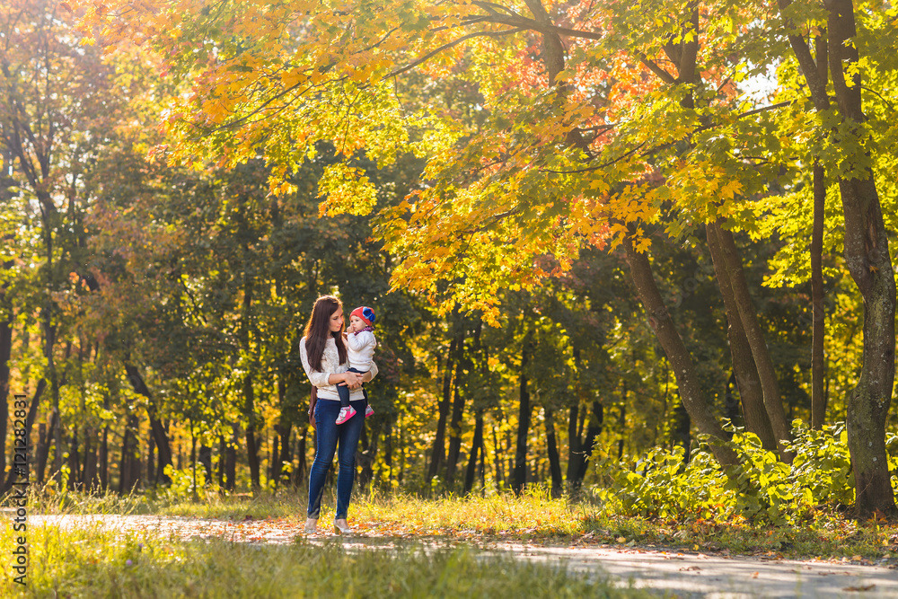 Fototapeta premium Young mother and her toddler girl have fun in autumn