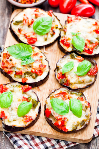 Baked eggplant with cheese and tomatoes on cutting board
