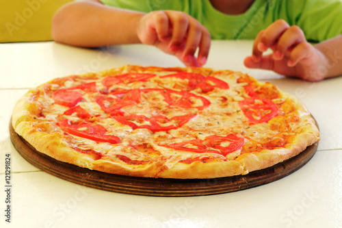 appetizing pizza Margherita and children's hands