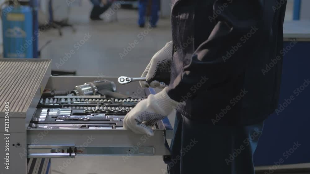Mechanic open Blue Metal Box with Different Tools for Car Repair at Modern Service station Mechanic open Blue Metal Box with Different Tools for Car Repair at Modern Service station