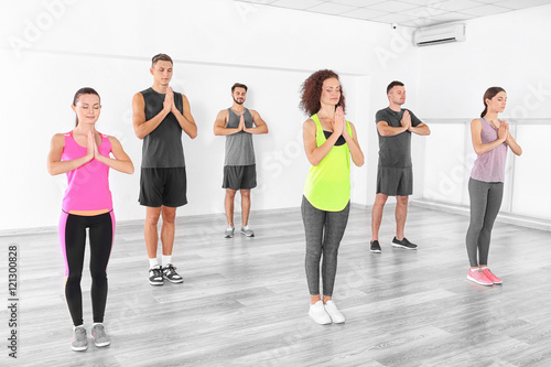 Group of people doing yoga exercises in gym