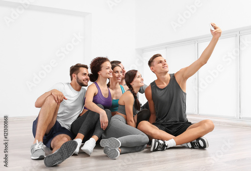 Sport concept. Group of people taking selfie in gym