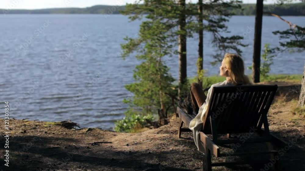 Woman Relaxing on a Lounger on a Cliff Forest Lake Woman Relaxing on a Lounger on a Cliff Forest Lake