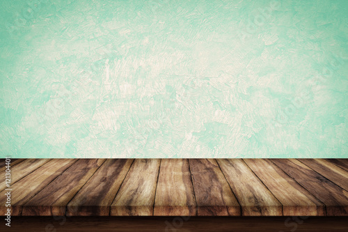 Empty wooden table with green wall background.