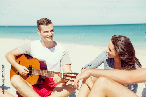 Beautiful young people with guitar on beach © Sergey Nivens