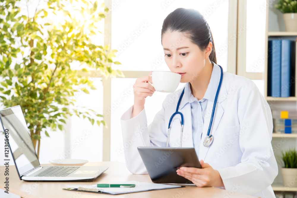 doctor drink coffee using digital tablet research patient's medi doctor drink coffee using digital tablet research patient's medi